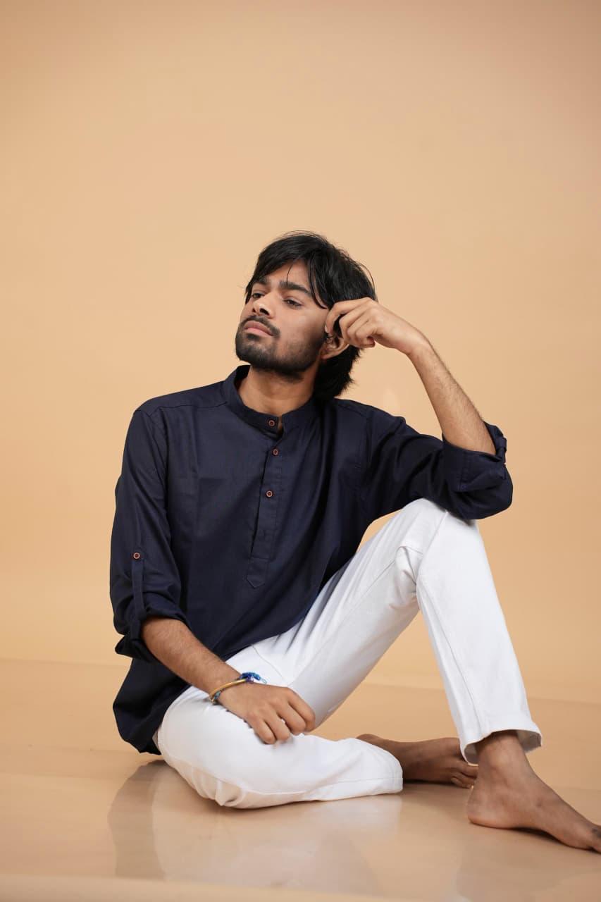 Seated on the floor in kurta, hand in hair